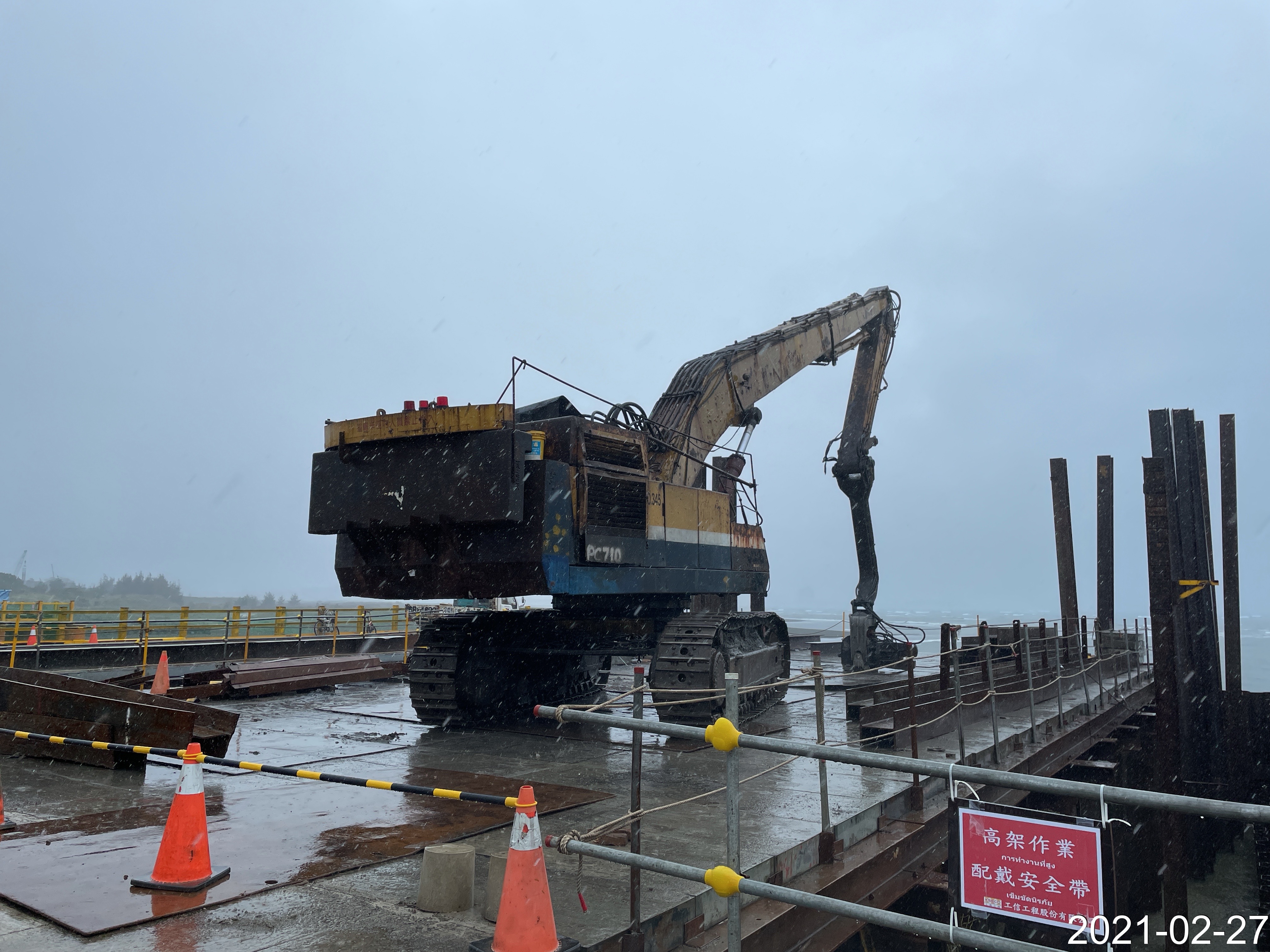 河中段施工構台上打設圍堰作業情況.